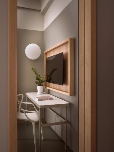 a room with a desk with a tv on a wall at City Hotel Thessaloniki in Thessaloniki