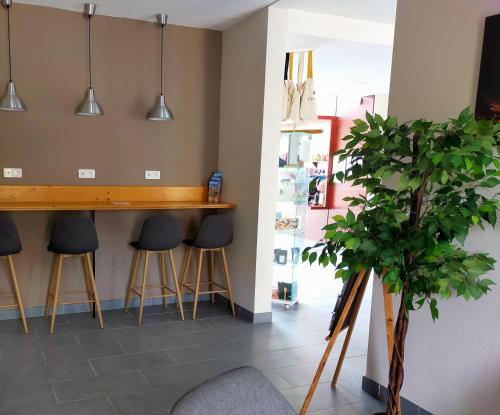 a bar in a room with stools and a plant at Comfort Aparthotel Carcassonne in Carcassonne