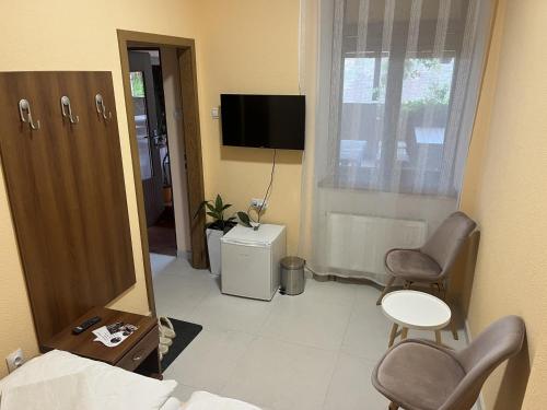 a room with a mirror and two chairs and a television at VT6 House & Restaurant in Znojmo