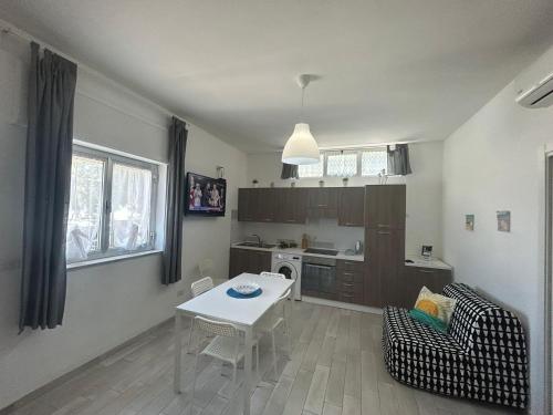 a living room with a table and a kitchen at SoleeMare Barletta in Barletta