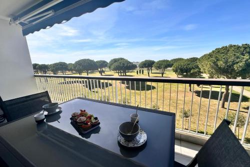 une table avec une assiette de nourriture sur un balcon dans l'établissement Le Mistral Appartement Standing avec Vue Mer Exceptionnelle en 1ère Ligne, au Grau-du-Roi