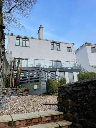 a large white house with glass windows at No1 Apartment Mevagissey in Mevagissey