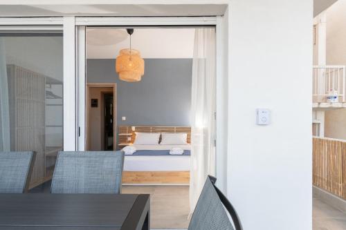 a bedroom with a bed and a table and chairs at Sandra Seaview Suites in Neos Marmaras