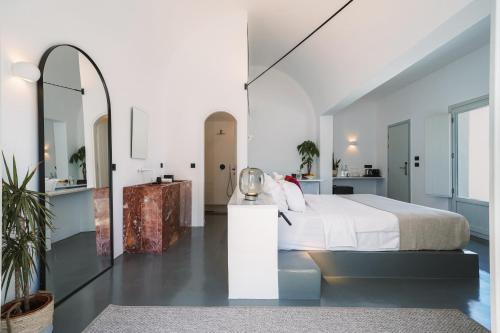 a bedroom with a white bed and a bathroom at Santonero in Akrotiri
