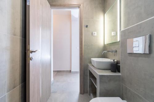 a bathroom with a sink and a toilet in it at Sandra Seaview Suites in Neos Marmaras