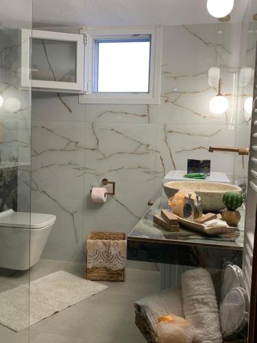 a bathroom with a toilet and a marble wall at House maria elenι in Skala Kallirachis