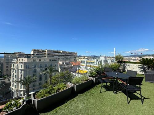 a balcony with a table and chairs on the grass at Hôtel de Provence in Cannes