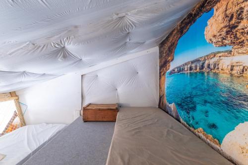 a bed in a tent with a view of the ocean at Repaire Des Pirates Sainte Marie in Sainte-Marie-la-Mer