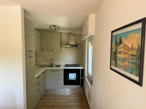 eine kleine Küche mit Spüle und Arbeitsplatte in der Unterkunft Casa Sole in Costermano sul Garda