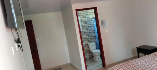 a room with a bathroom with a toilet and a doorway at Hotel Alta Vista Campestre in Tibasosa