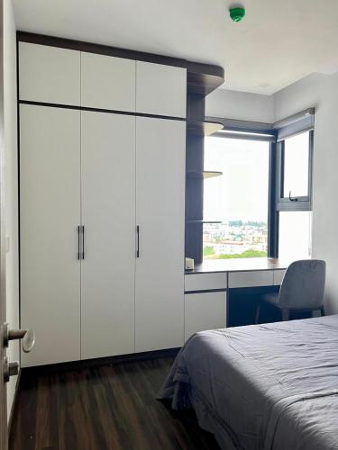 a bedroom with white cabinets and a bed and a window at LeeVy Hai Phong in Hai Phong
