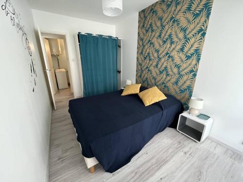 - une chambre avec un lit doté de draps bleus et d'oreillers jaunes dans l'établissement Charmant appartement avec parking, à 50m de la plage - FR-1-324A-25, à Saint-Hilaire-de-Riez