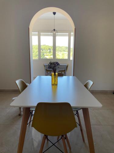 a white table with chairs and a vase of flowers on it at Santa Eufè in Tricase
