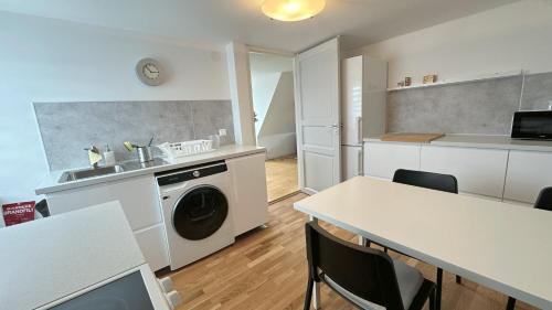 a kitchen with a washer and a sink and a washing machine at Cozy Villa apartment in Malmö