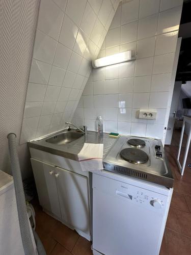 une petite cuisine avec un évier et une cuisinière dans l'établissement Gîtes Place Plumereau de Tours, à Tours