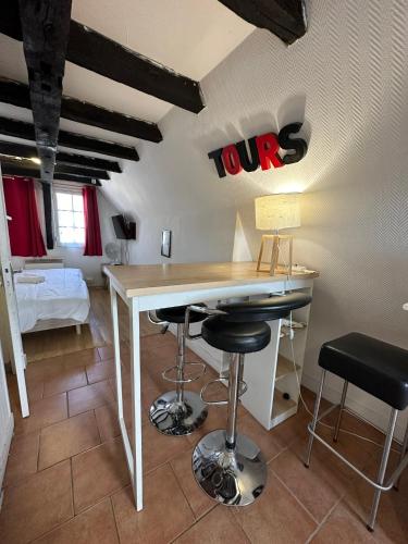 Cette chambre comprend un bureau et des tabourets. dans l'établissement Gîtes Place Plumereau de Tours, à Tours