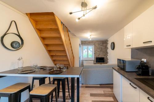 une cuisine avec une table et quelques chaises dans une pièce dans l'établissement T2 Contemporain idéalement situé, à Briançon