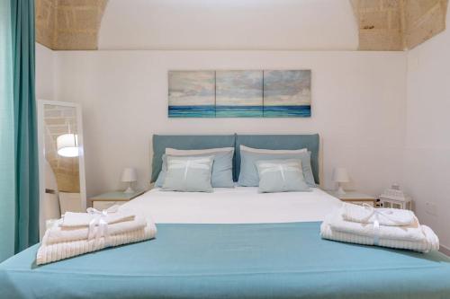 a bedroom with a large blue bed with two towels at Al Duomo in Brindisi