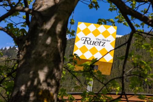 a sign for the rutil supermarket is seen through trees at Haus Freunden in Sankt Anton am Arlberg