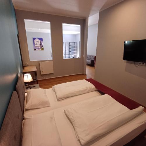 a room with two beds and a flat screen tv at Trip Inn Hotel Düsseldorf Neuss in Neuss