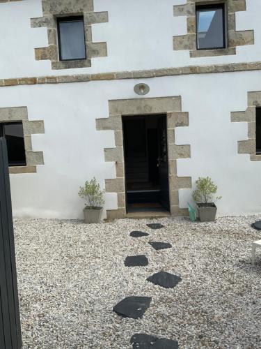 a building with a door and a gravel courtyard at Penty de charme - Plogoff Pors Loubous in Plogoff