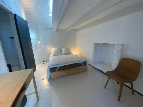 a bedroom with a bed and a desk and a chair at Penty de charme - Plogoff Pors Loubous in Plogoff