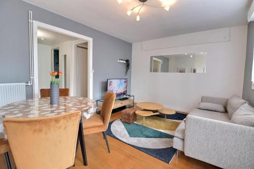 ein Wohnzimmer mit Tisch und Couch in der Unterkunft Le Payen - 3 chb Confort - balcon - Mon Groom in Troyes