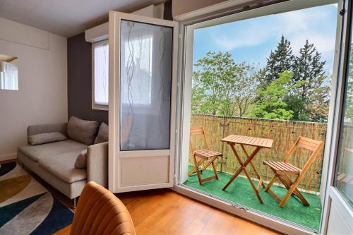 - un salon avec une porte coulissante en verre, une table et des chaises dans l'établissement Le Payen - 3 chb Confort - balcon - Mon Groom, à Troyes