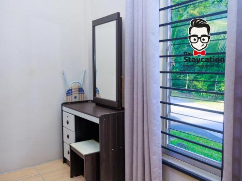 a bedroom with a dresser with a mirror and a window at Staycation Homestay 50 Peaceful Villa Damai in Kuching