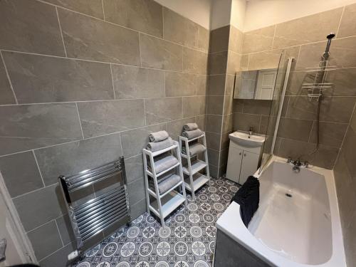 a bathroom with a tub and a sink and a toilet at 34-2 mansfield road in Hawick
