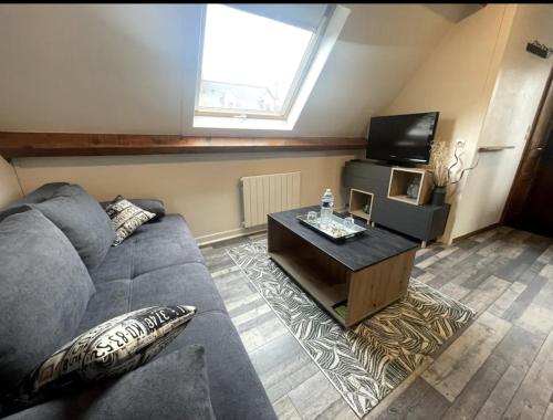 un salon avec un canapé et une télévision dans l'établissement Studio, Escale GREEN, à Saint-Valery-en-Caux