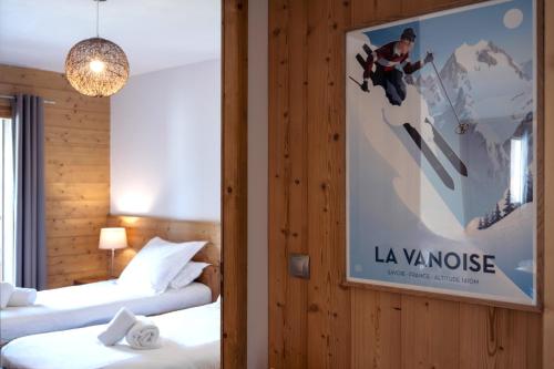 a room with two beds and a poster on the wall at ALPA appartements - Champagny-en-Vanoise in Champagny-en-Vanoise