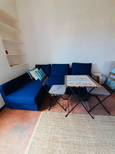 a living room with a blue couch and a table at Portoferraio Old City Studio in Portoferraio
