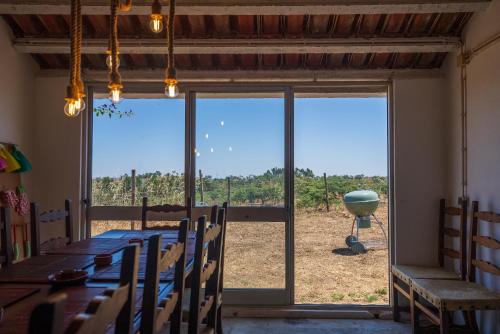 a dining room with a table and a large window at A Casinha in São Bartolomeu da Serra