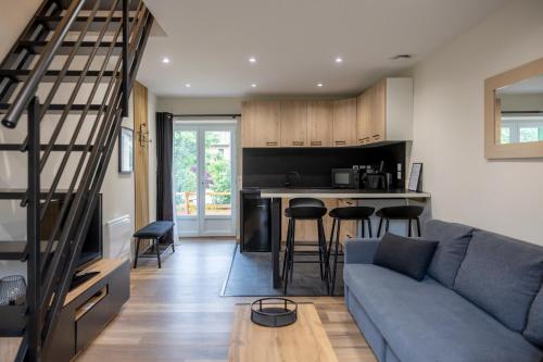 un salon avec un canapé bleu et une cuisine dans l'établissement Superbe T2 jacuzzi hammam #4, à Briançon