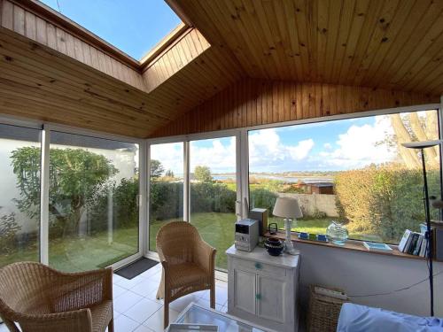 une véranda avec vue sur le jardin dans l'établissement Maison plain-pied avec jardin, à 350m de la plage, WIFI, à Pleumeur-Bodou - FR-1-368-358, à Pleumeur-Bodou