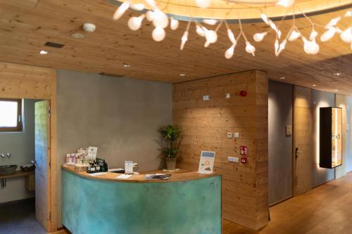 a lobby with a counter in a room with wooden walls at Hotel Gran Paradiso in San Cassiano