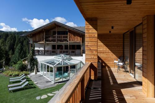 an external view of a house with a glassconservatory at Hotel Gran Paradiso in San Cassiano