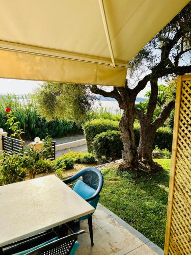 a table and chairs and a table and a tree at Terpsichori villa and apartments in Kalamaki