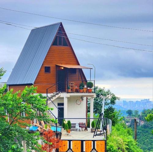a house with a gambrel roof with a balcony at Mountain Star in Batumi