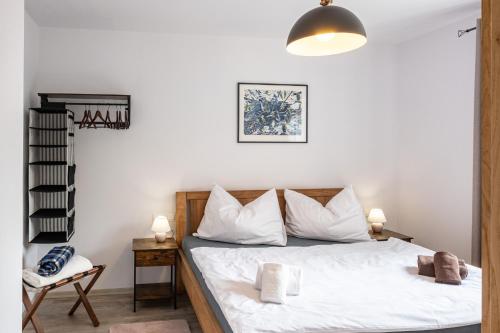 a bedroom with a bed with white sheets and pillows at Miner's Lodge in Jáchymov