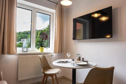a table and chairs in a room with a window at Miner's Lodge in Jáchymov