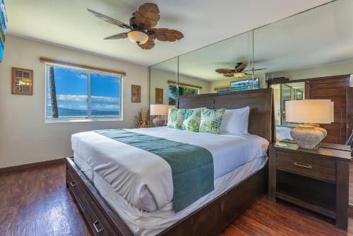 a bedroom with a large bed with a ceiling fan at Maalaea Kai 220 in Wailuku