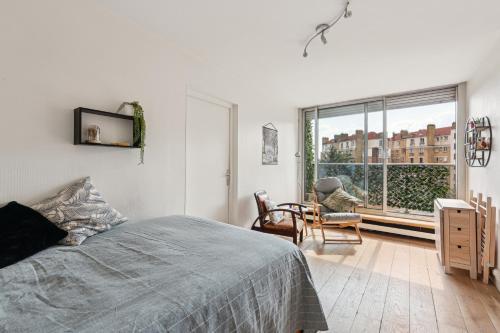 une chambre avec un lit et une grande fenêtre dans l'établissement Appartement calme et lumineux Place d'Italie by Weekome, à Paris