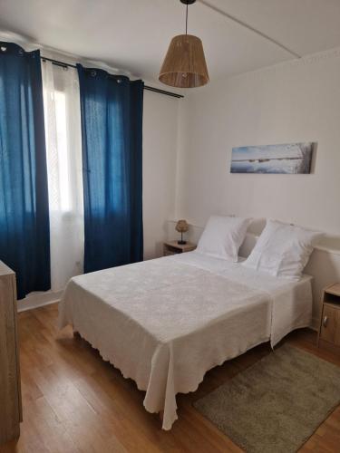 une chambre avec un grand lit avec des rideaux bleus dans l'établissement Brasserie l'inédit, à Bondy