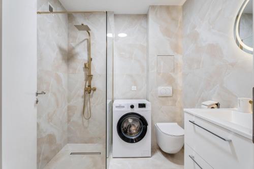 La salle de bains est pourvue d'une douche et d'un lave-linge. dans l'établissement Studio elegant avec balcon proche Mer et Tramway, à Nice