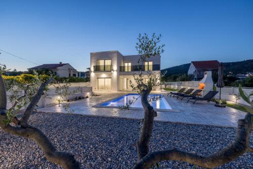 ein Haus mit einem Swimmingpool im Hof in der Unterkunft Villa Sea View - heated pool & 2 mins to the beach in Vinišće