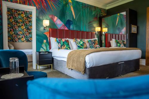 a bedroom with a large bed with a tropical mural at Balmer Lawn in Brockenhurst