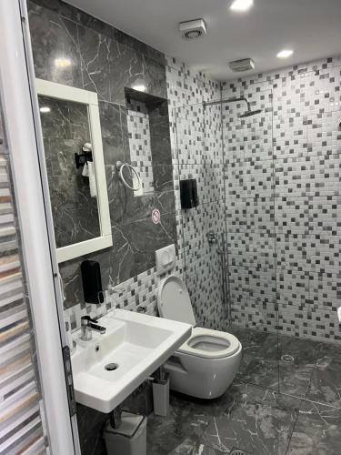 a bathroom with a toilet and a sink at Ilio Boutique Hotel in Ksamil