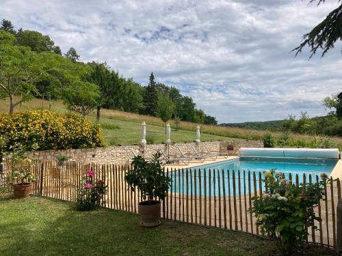 a fence around a swimming pool in a yard at La Bastide Portoly Gîte "Les Deux Cèdres" in Penne-dʼAgenais